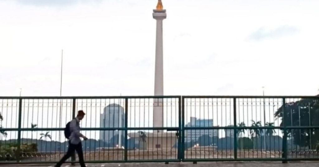 99057-ilustrasi-warga-saat-melintas-di-depan-tugu-monas-jakarta